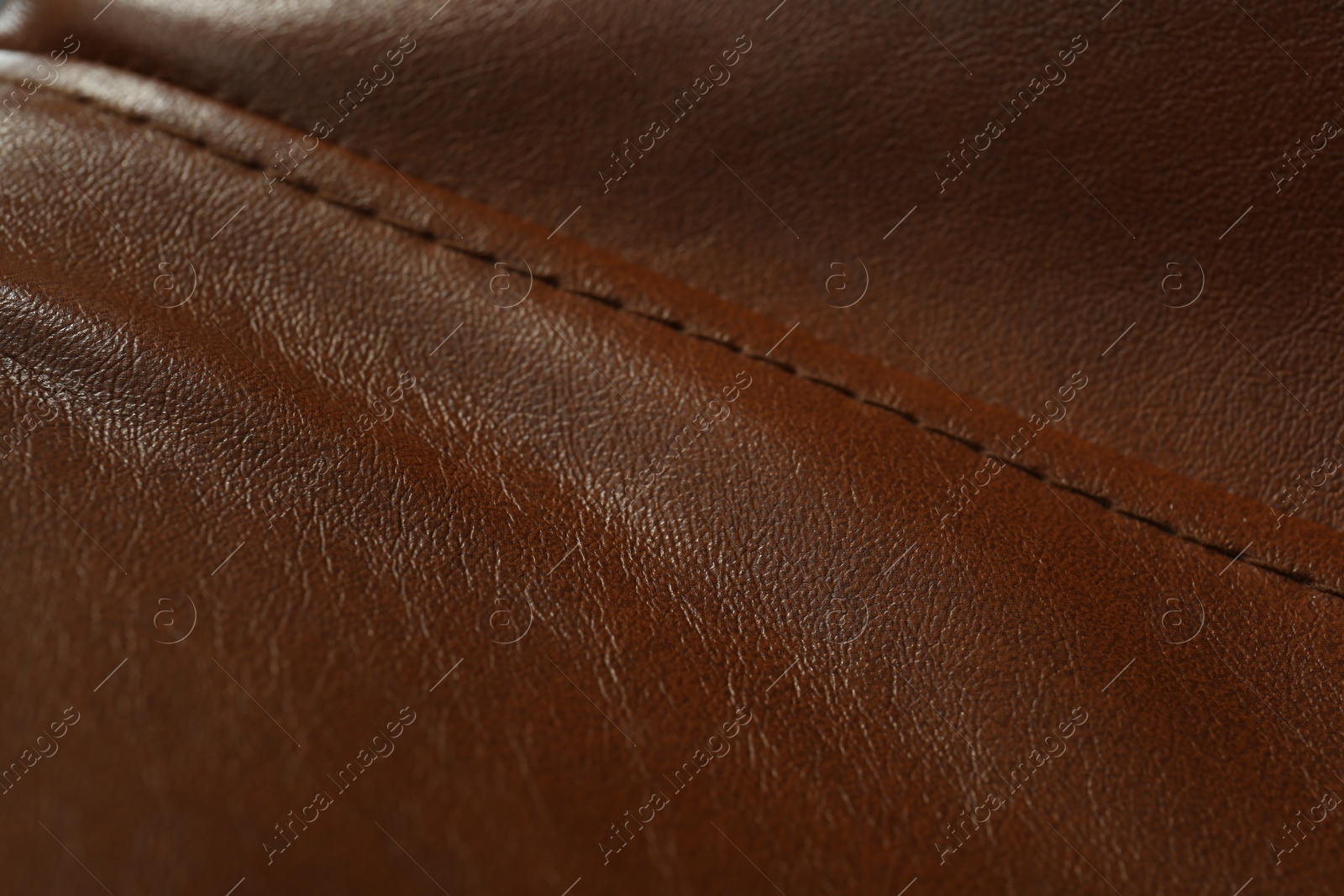 Photo of Brown leather with seam as background, closeup