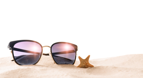 Stylish sunglasses and starfish on sand against white background. Space for text