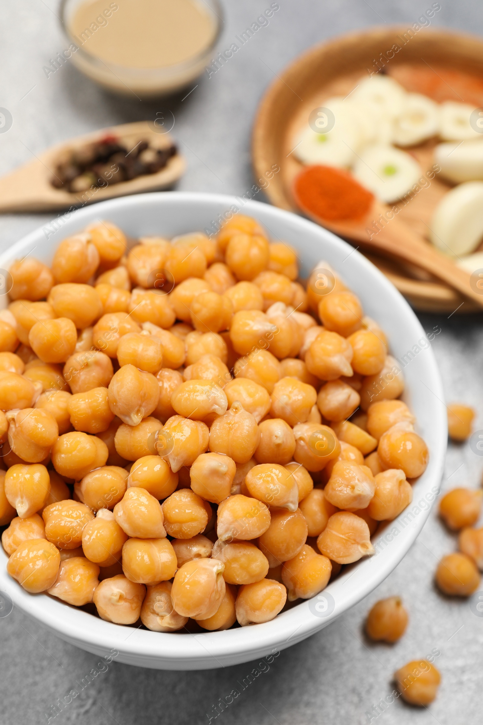 Photo of Delicious chickpeas on light grey table, closeup. Hummus ingredient