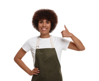 Happy young woman in apron showing thumb up on white background