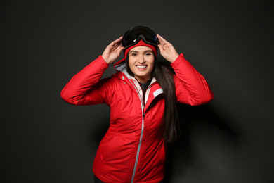 Photo of Woman wearing stylish winter sport clothes on black background