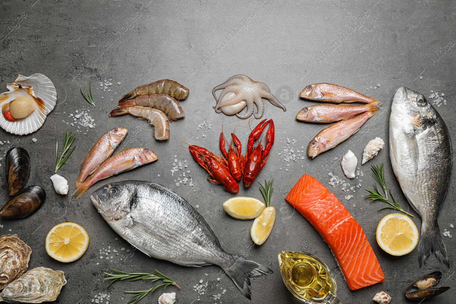 Photo of Fresh fish and seafood on grey table, flat lay