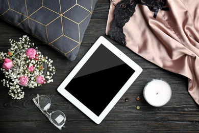 Flat lay composition with tablet and stylish clothes on wooden background. Blogger concept