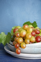 Photo of Fresh ripe juicy grapes in dishware on table