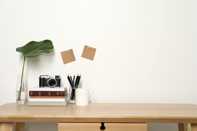 Photo of Comfortable workplace with wooden desk near white wall at home