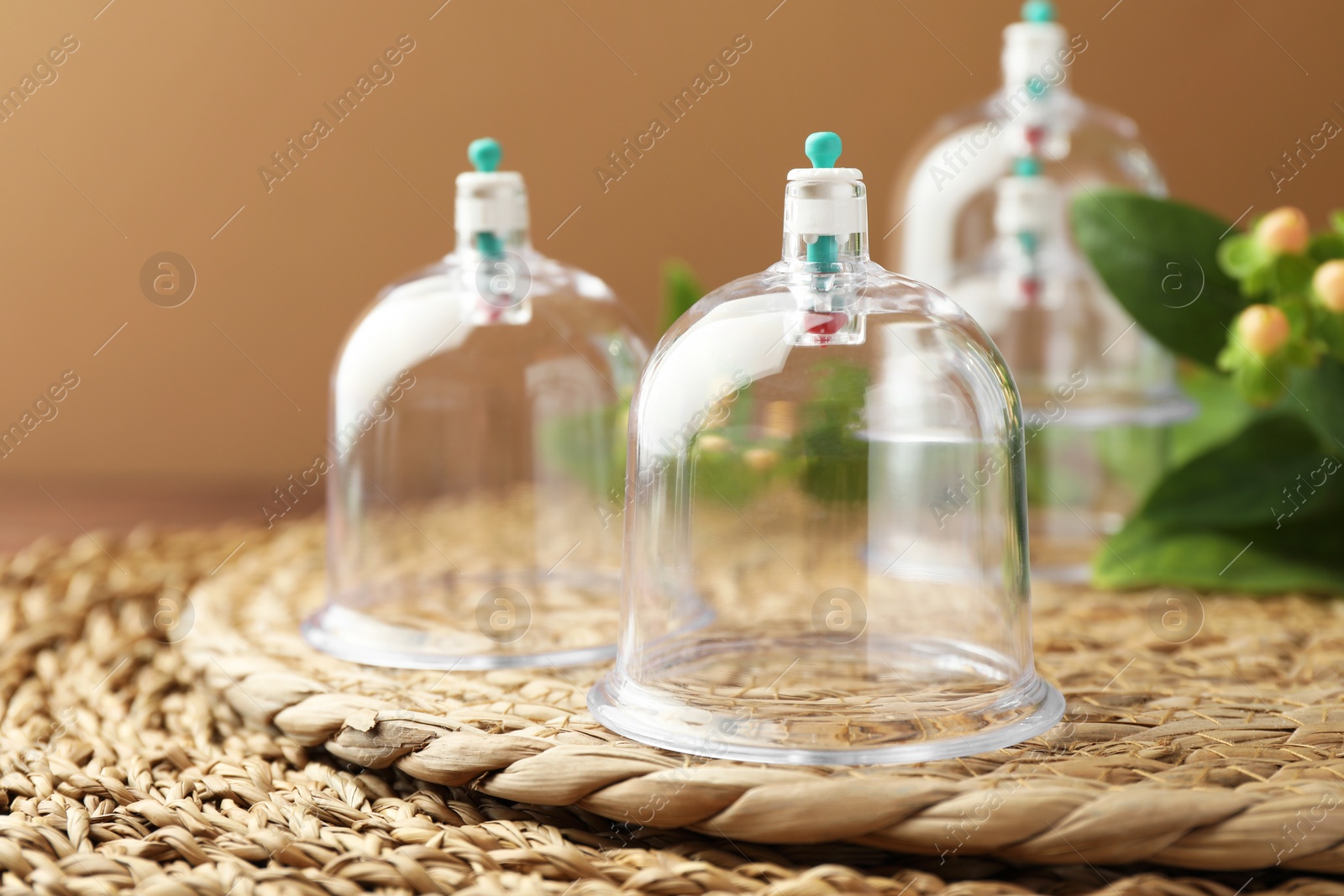 Photo of Cupping therapy. Plastic cup on wicker mat, closeup