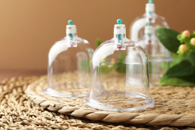 Cupping therapy. Plastic cup on wicker mat, closeup