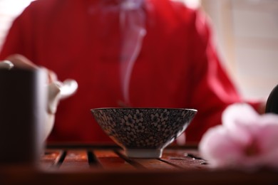 Photo of Steam raising above cup on tray. Traditional tea ceremony
