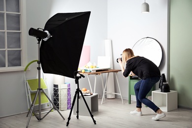 Photo of Woman taking photo of food with professional camera in studio