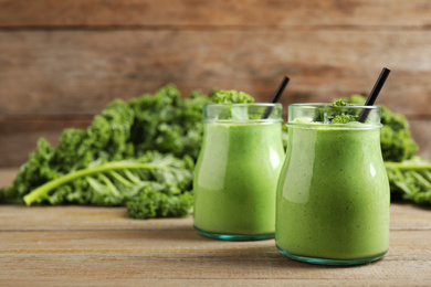 Photo of Tasty fresh kale smoothie on wooden table