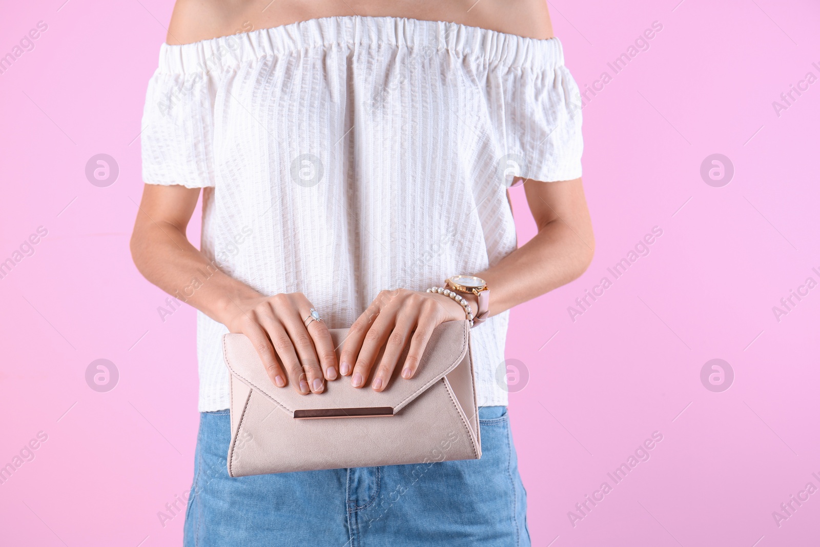 Photo of Young woman in stylish outfit with purse on color background, closeup