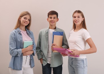 Photo of Group of teenage students with stationery on beige background