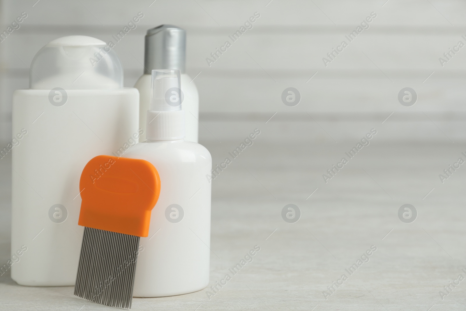 Photo of Different cosmetic products and lice comb on light table. Space for text