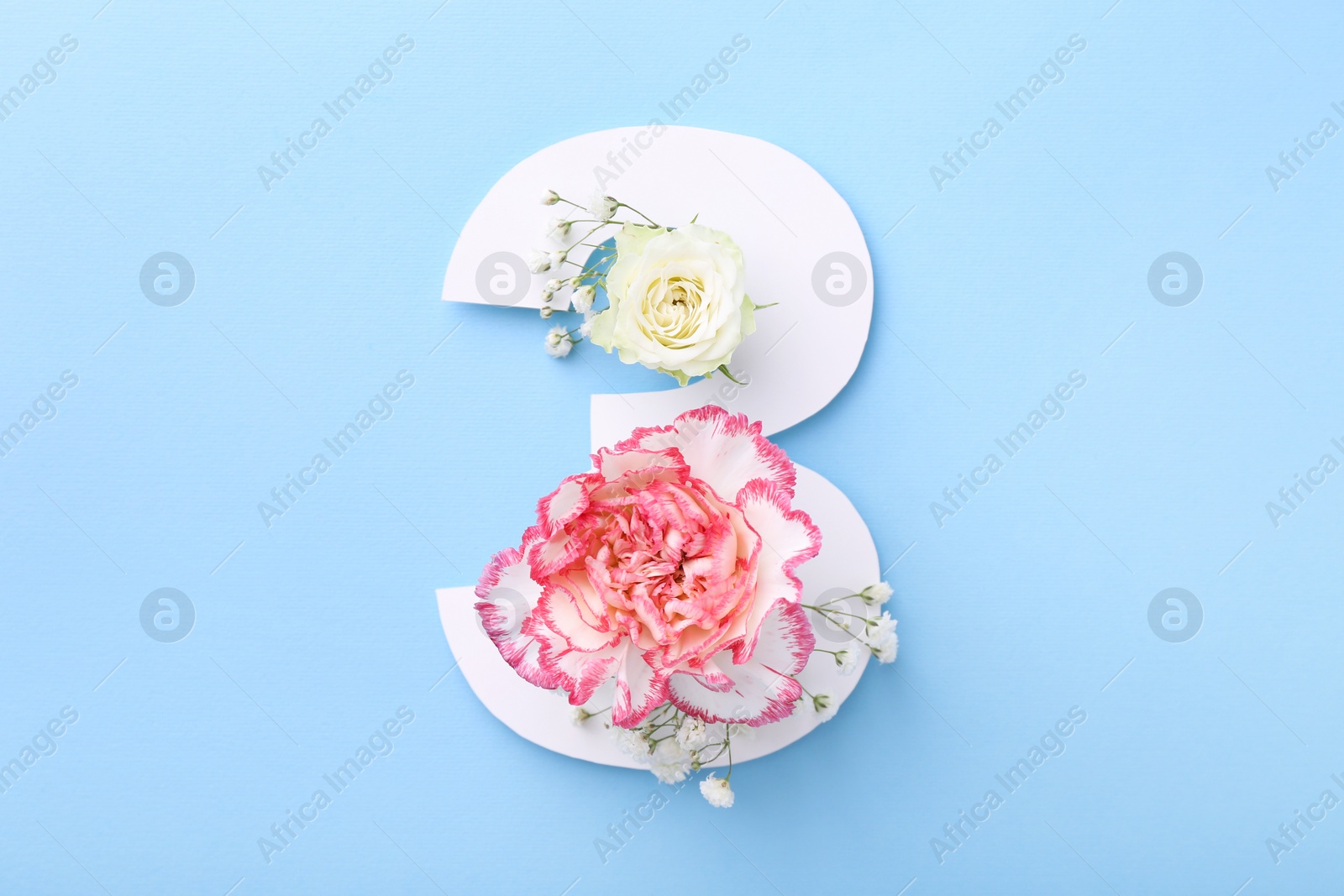 Photo of Paper number 3 and beautiful flowers on light blue background, top view