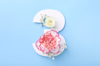 Photo of Paper number 3 and beautiful flowers on light blue background, top view