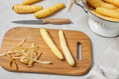 Photo of Peeled white carrots on wooden cutting board