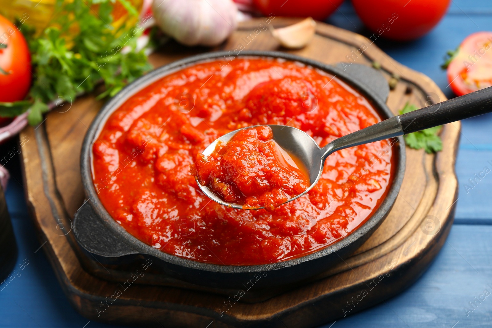 Eating homemade tomato sauce at blue table, closeup Photo of Eating homemade tomato sauce at blue table, closeup