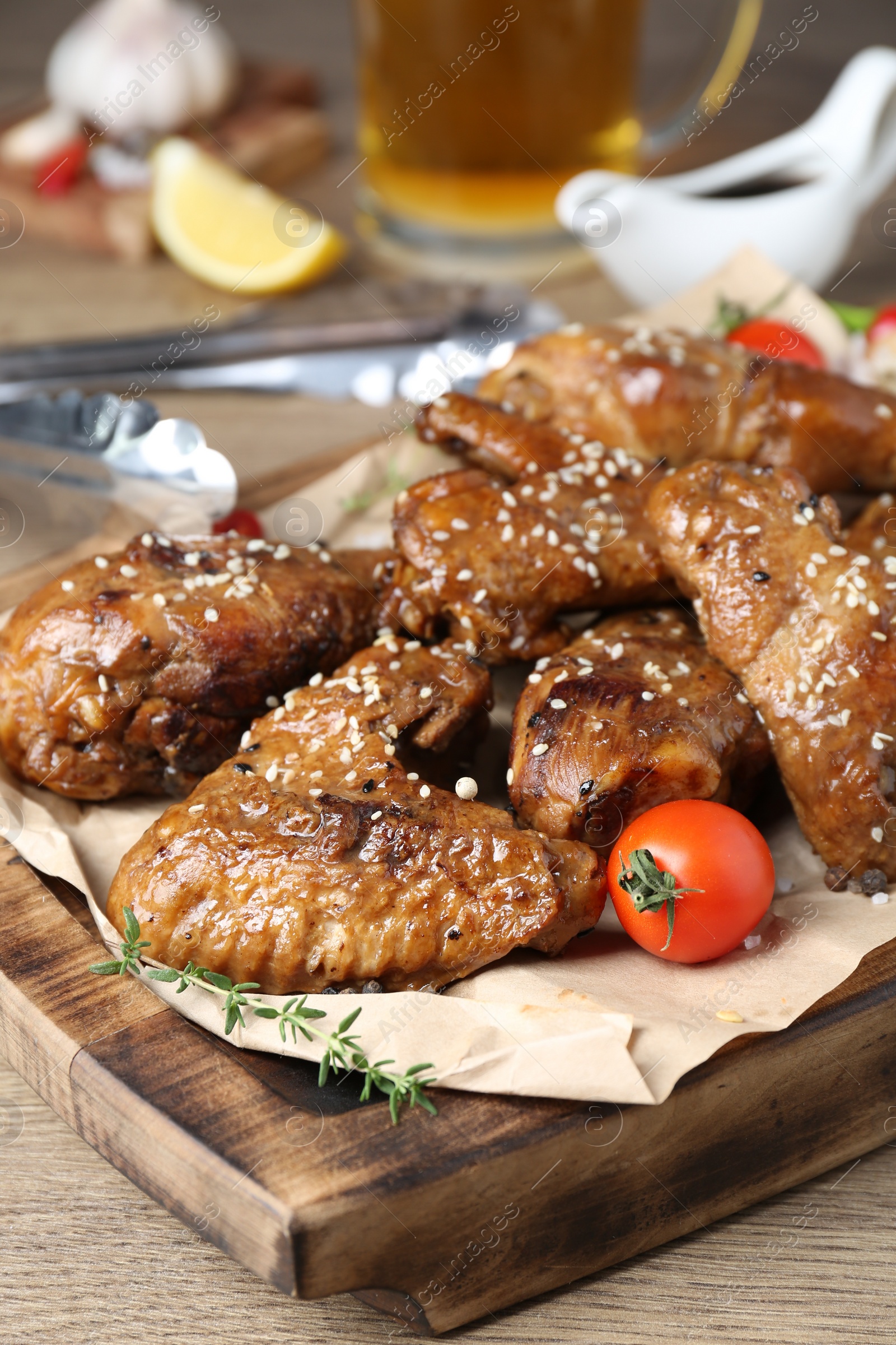 Photo of Tasty chicken glazed in soy sauce served on wooden table, closeup