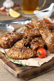 Photo of Tasty chicken glazed in soy sauce served on wooden table, closeup