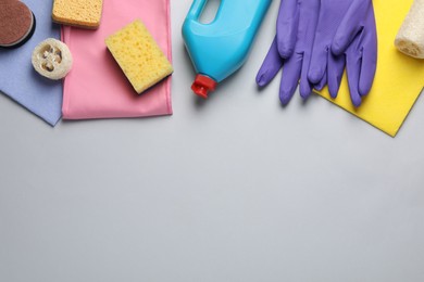 Photo of Flat lay composition with sponges and other cleaning supplies on light grey background. Space for text