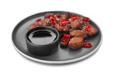 Photo of Plate with tasty soy sauce, roasted meat, sesame and chili pepper isolated on white