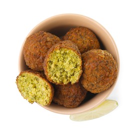 Photo of Delicious falafel balls in bowl and lime slice isolated on white, top view