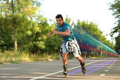 Image of Young man roller skating outdoors. Light trails showing his speed