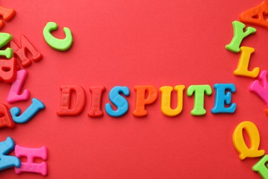 Photo of Word Dispute made of colorful letters on red background, flat lay