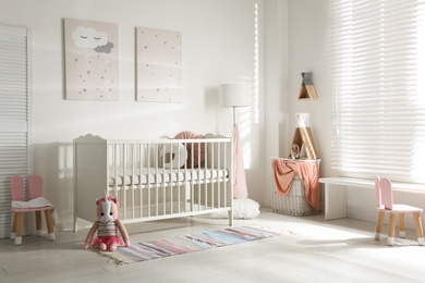 Cute baby room interior with crib and decor elements