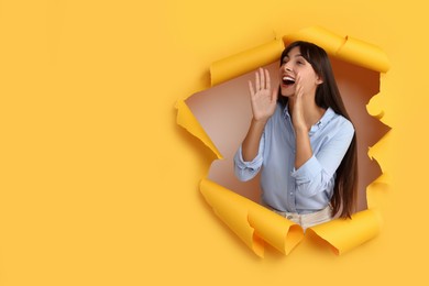 Photo of Special promotion. Woman shouting through hole in orange paper. Space for text