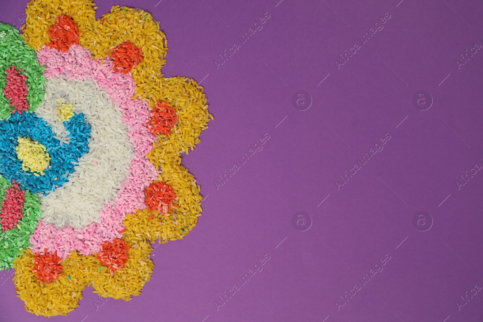 Photo of Diwali celebration. Colorful rangoli on purple background, top view. Space for text