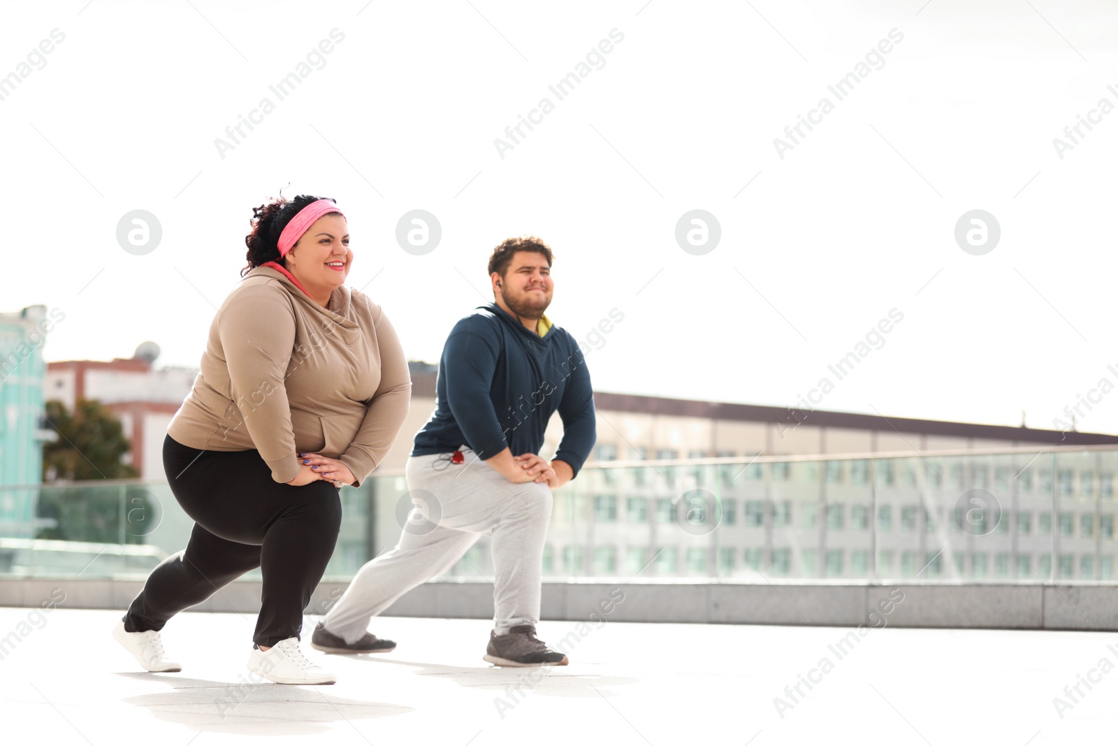 Photo of Overweight couple doing sport exercises together outdoors