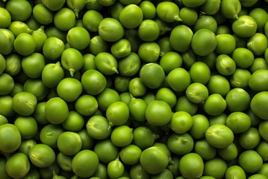 Fresh raw green peas as background, top view