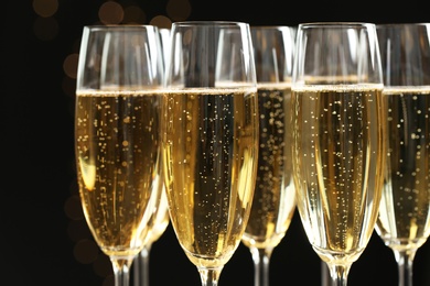 Glasses of champagne on dark background, closeup