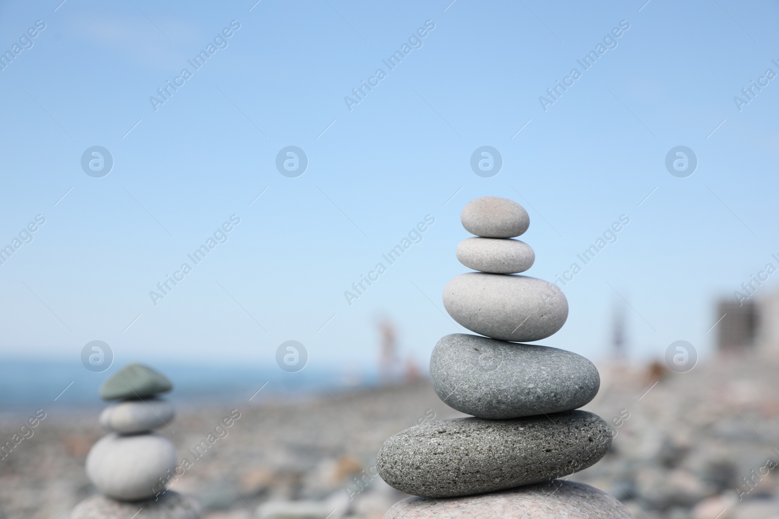 Photo of Stack of stones on beach against blurred background, closeup. Space for text