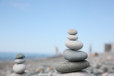 Stack of stones on beach against blurred background, closeup. Space for text