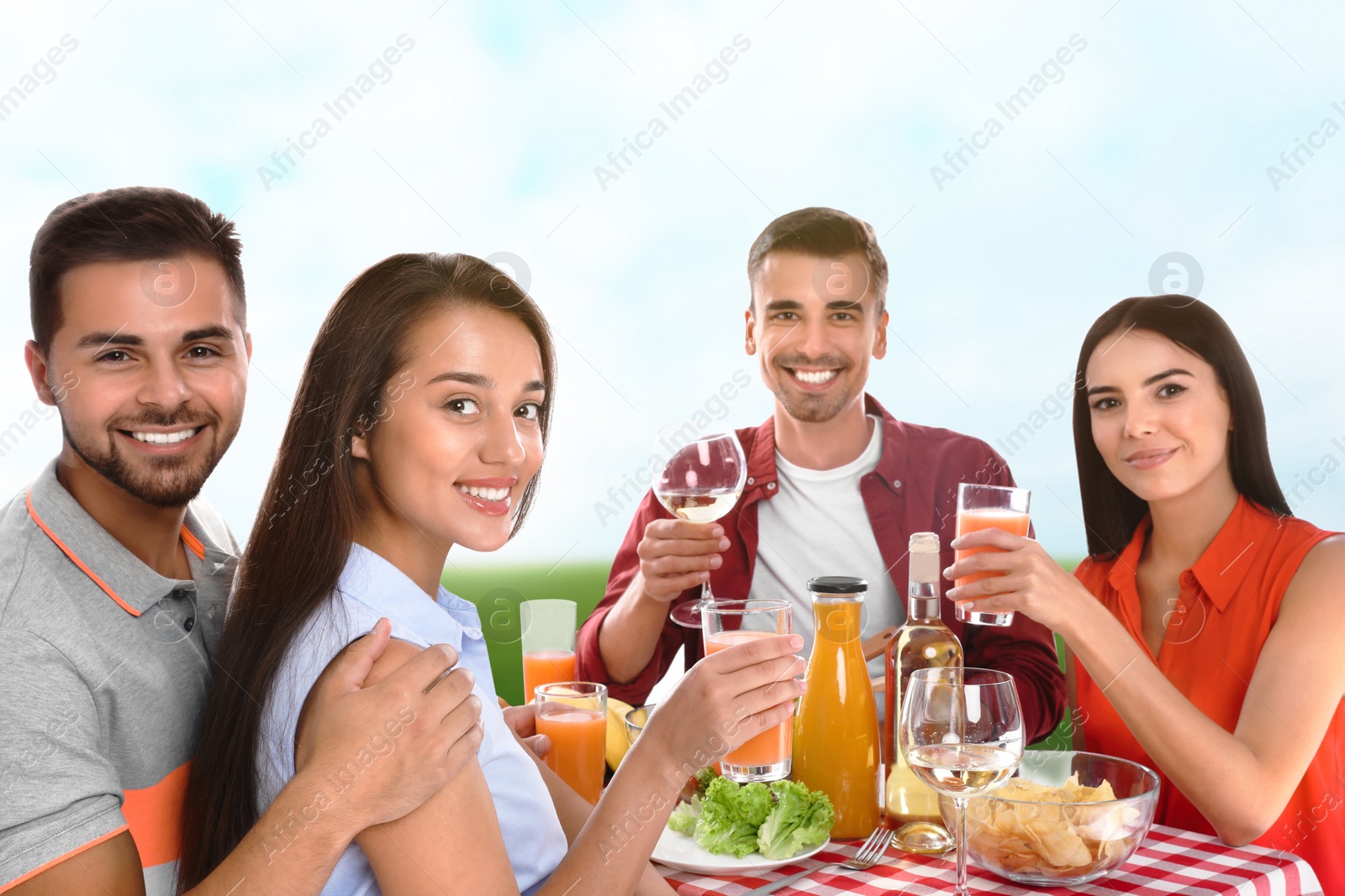 Image of Group of friends having picnic at table in park