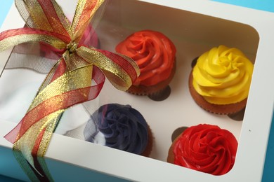 Box with many delicious colorful cupcakes, closeup