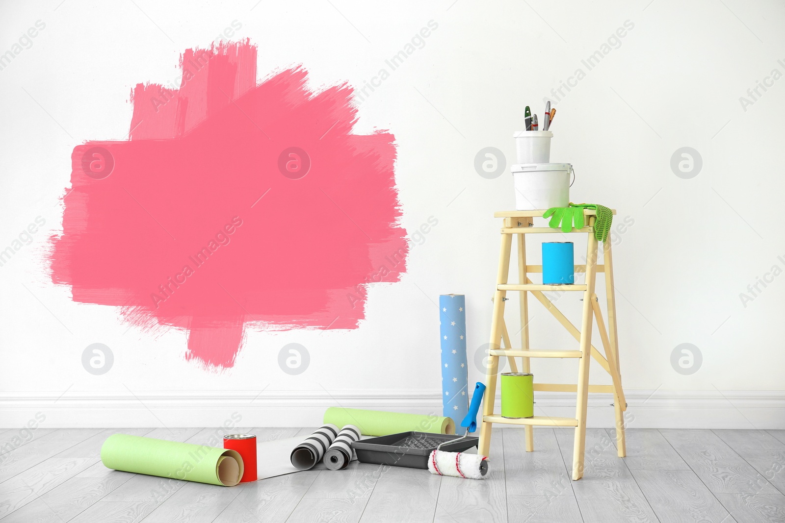 Image of Set with decorator's tools and paint on floor near white wall