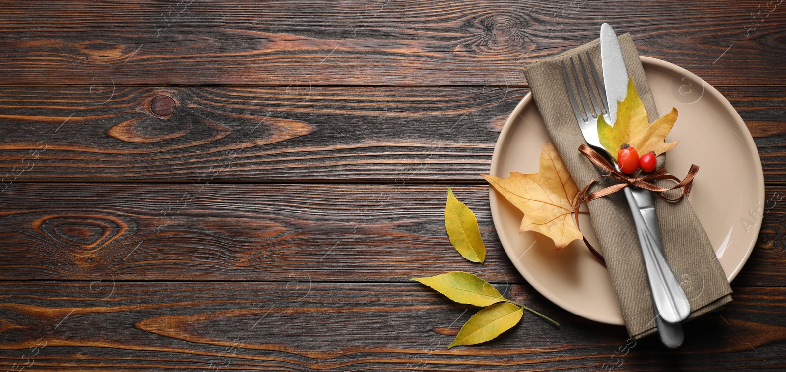 Image of Happy Thanksgiving Day, banner design. Festive table setting with autumn leaves and space for text on wooden background, flat lay