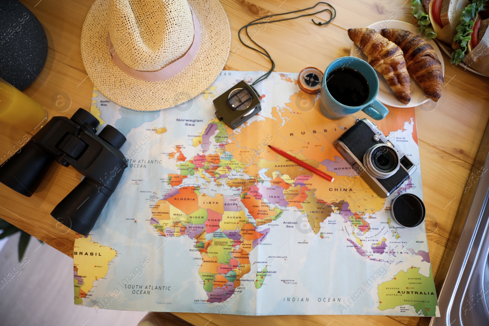 Photo of Flat lay composition with travel accessories on wooden table in motorhome. Summer trip