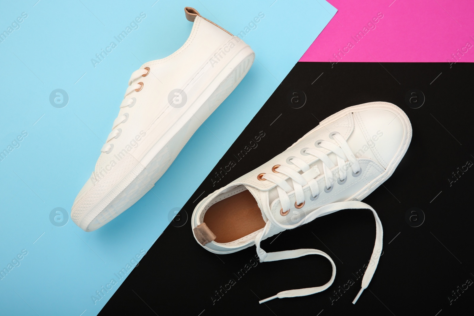 Photo of Pair of casual shoes on color background