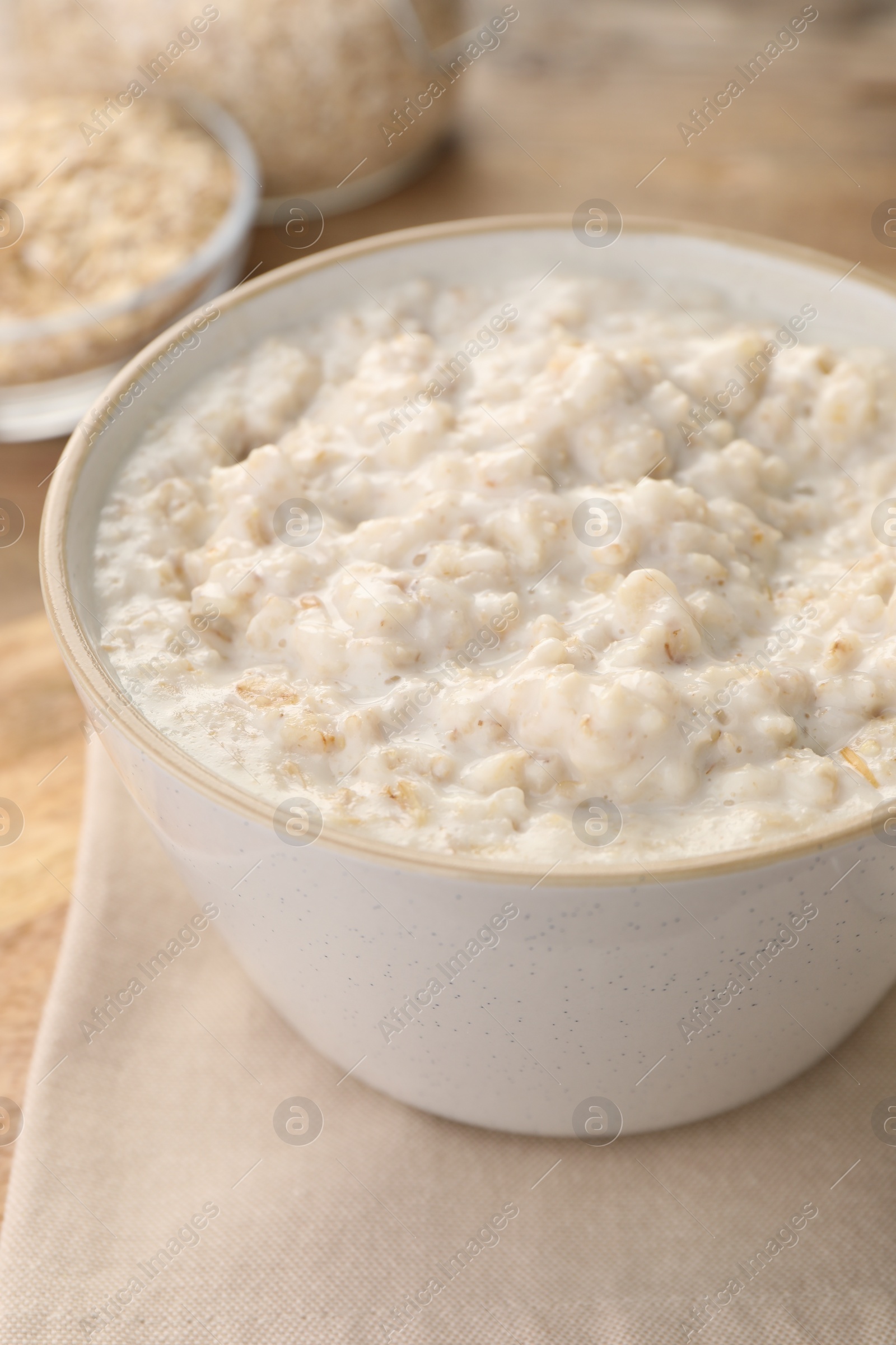 Photo of Tasty boiled oatmeal in bowl on table, closeup