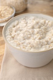 Photo of Tasty boiled oatmeal in bowl on table, closeup