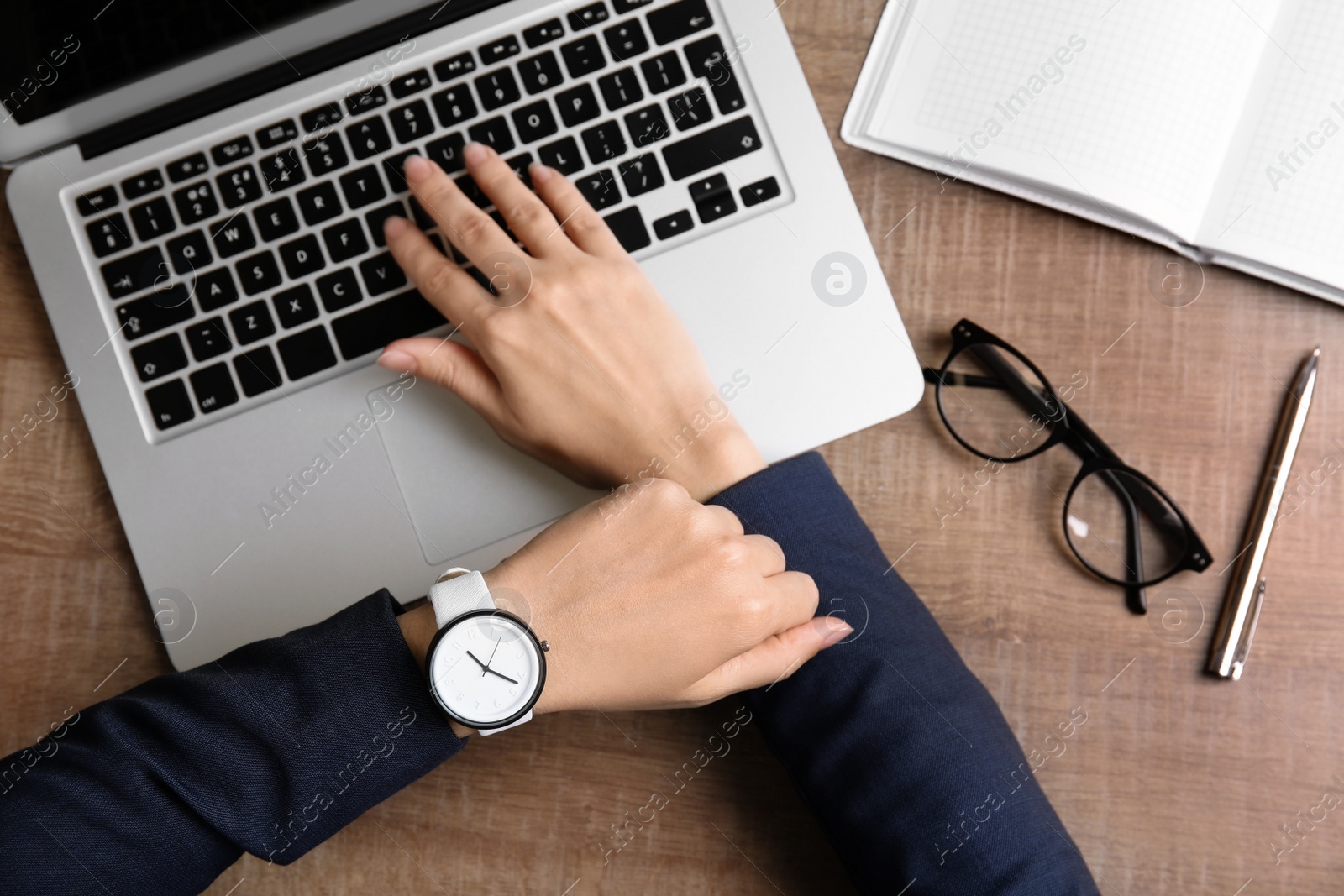 Photo of Businesswoman with stylish wrist watch working at office table, top view. Time management