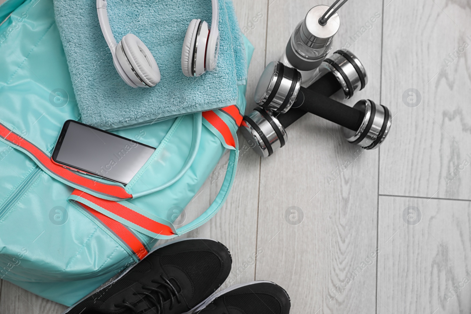 Photo of Sports bag and gym stuff on wooden floor, above view