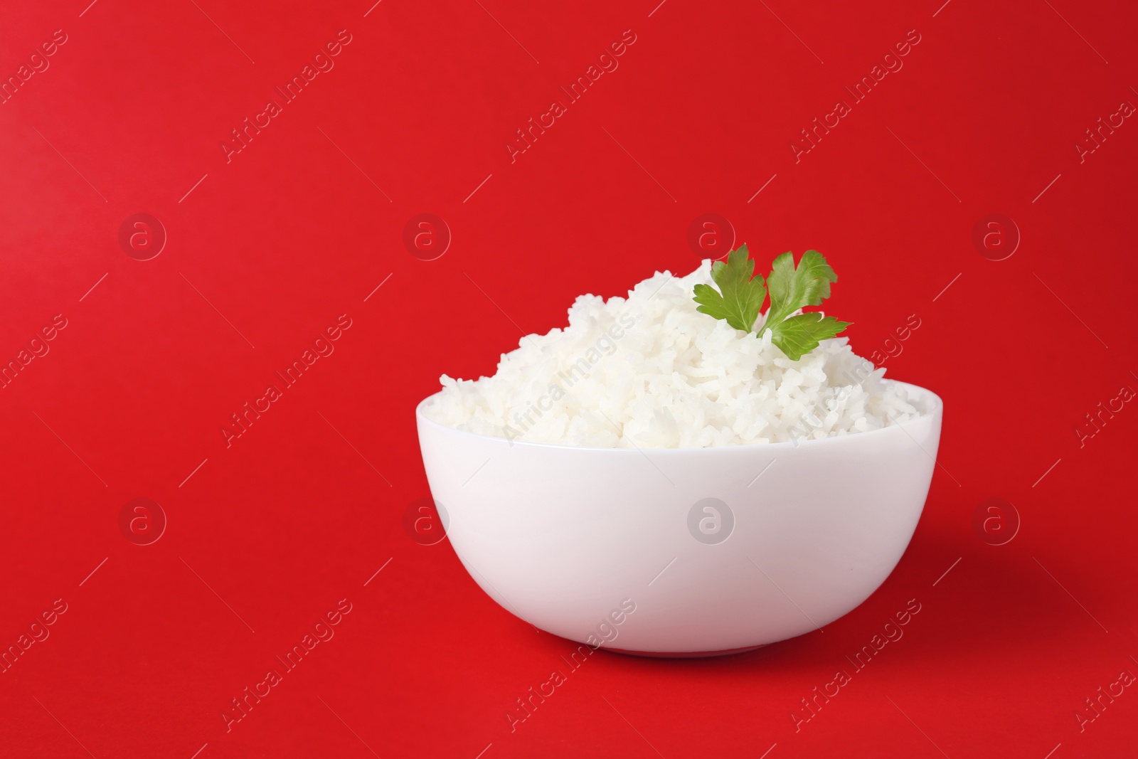 Photo of Bowl of boiled rice on color background. Space for text