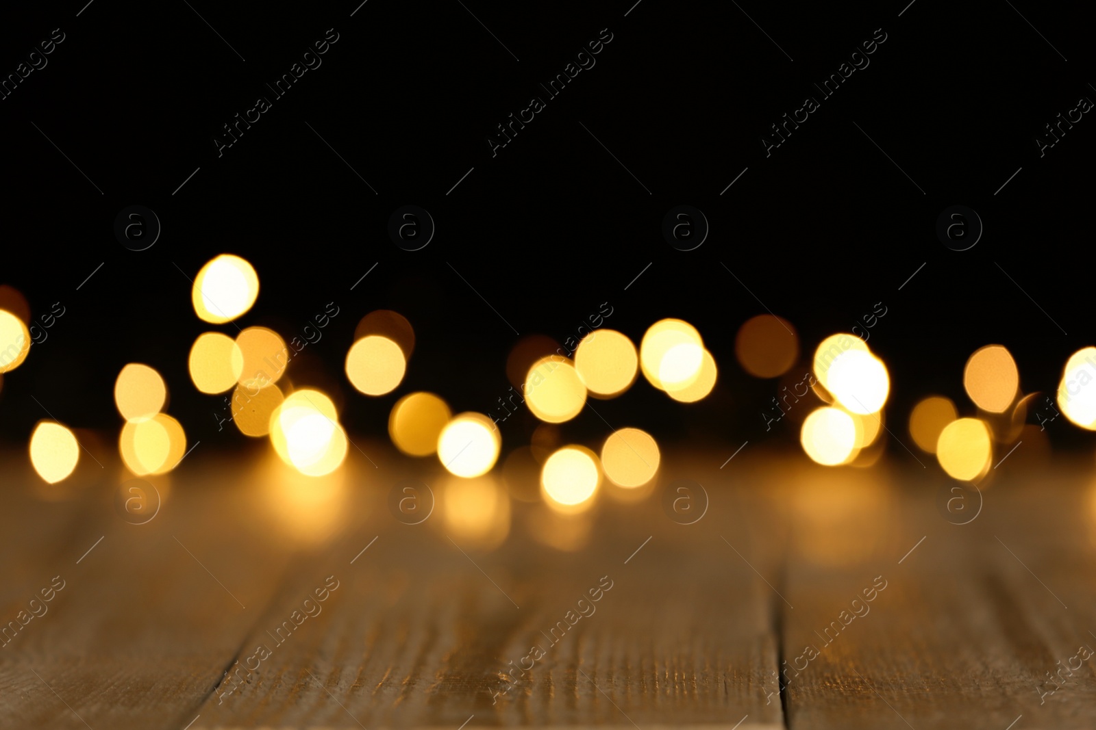 Photo of Wooden table and festive lights. Bokeh effect