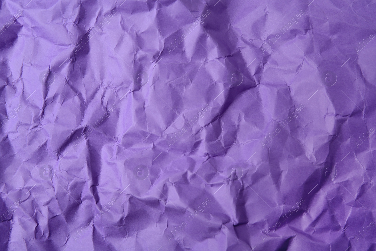 Photo of Sheet of crumpled violet paper as background, top view
