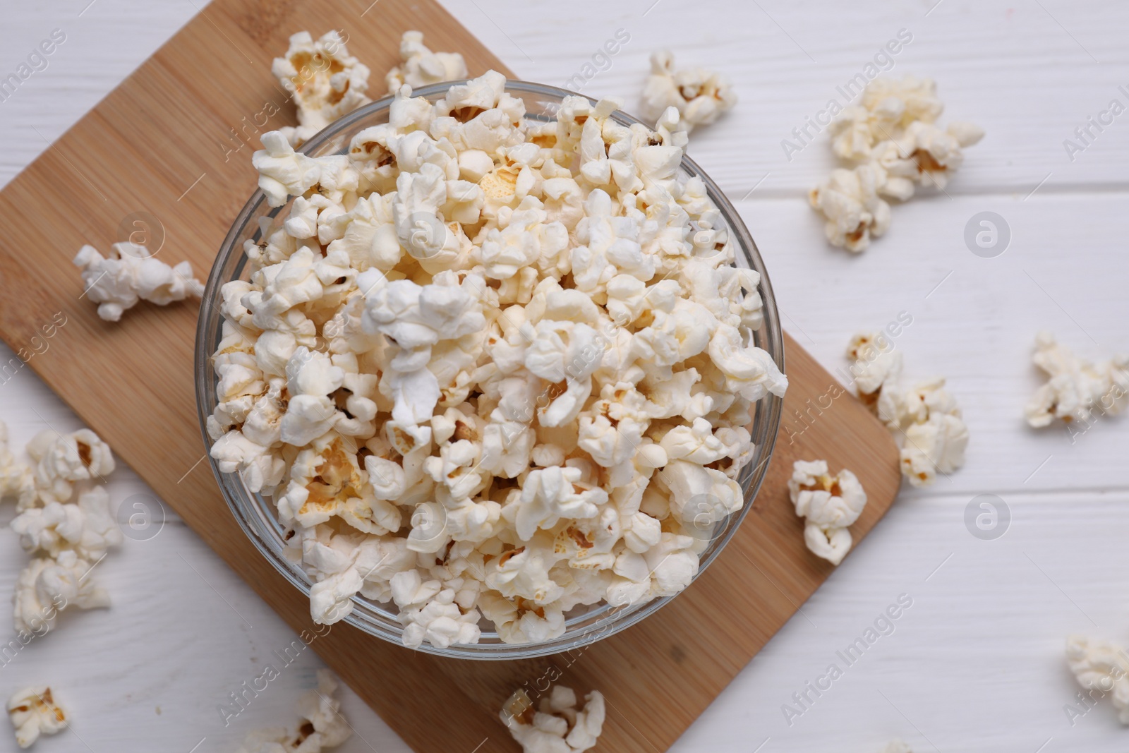 Photo of Tasty popcorn on white wooden table, flat lay